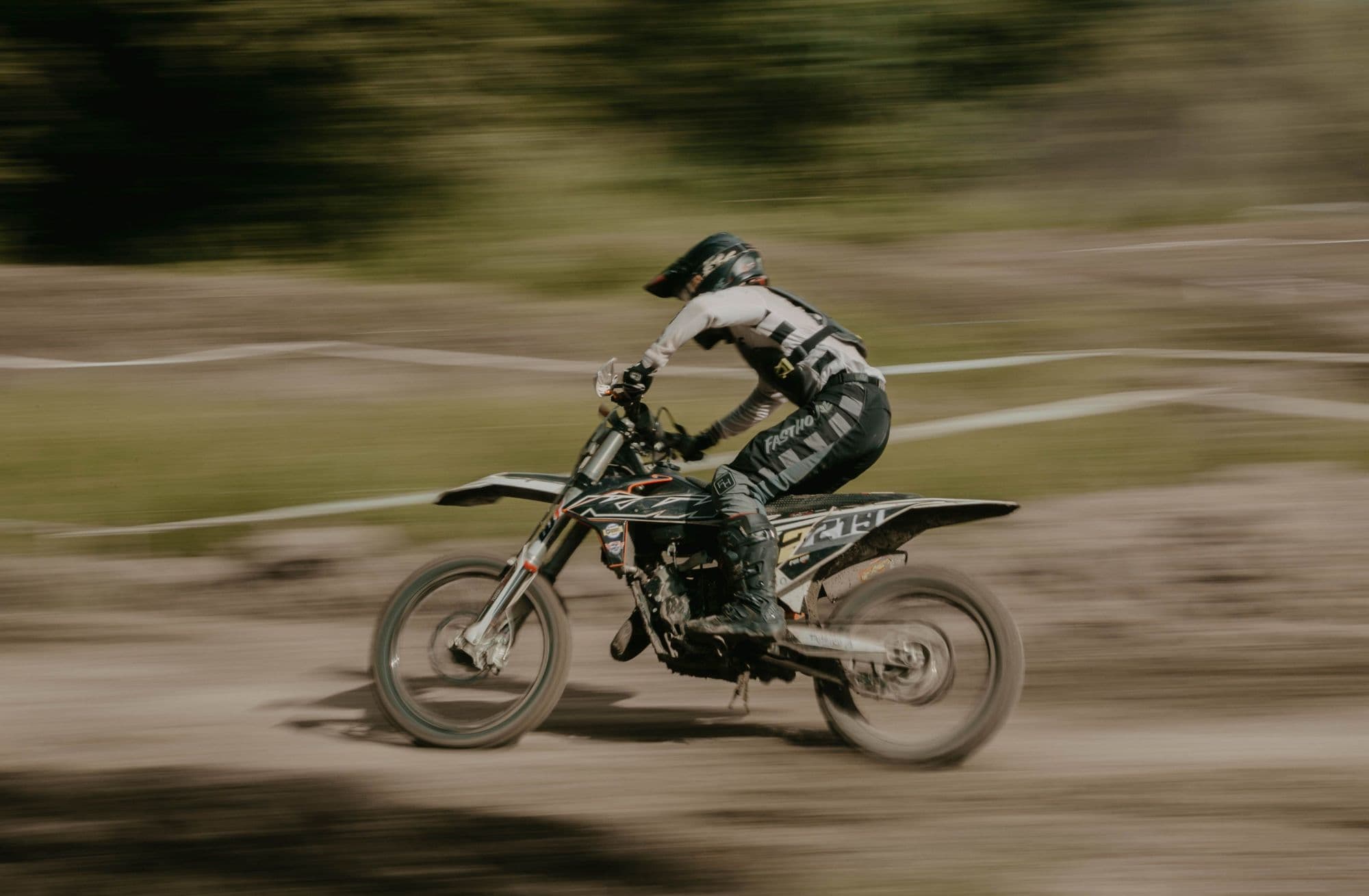 Rider in full protective kit at speed on a dirt track