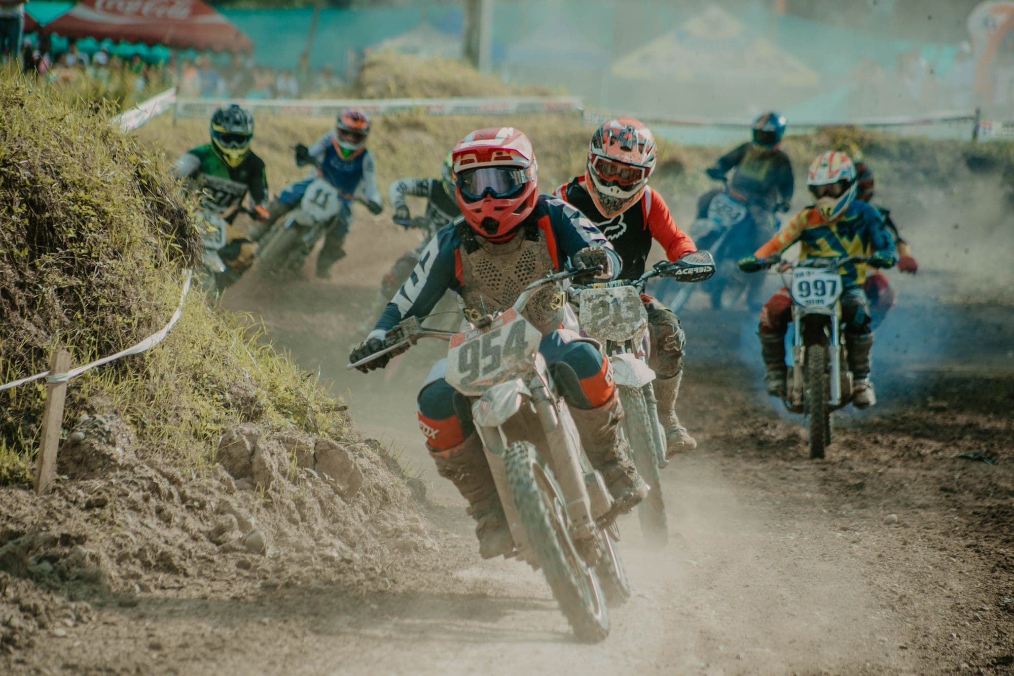 Young riders racing in a pack round a dusty track