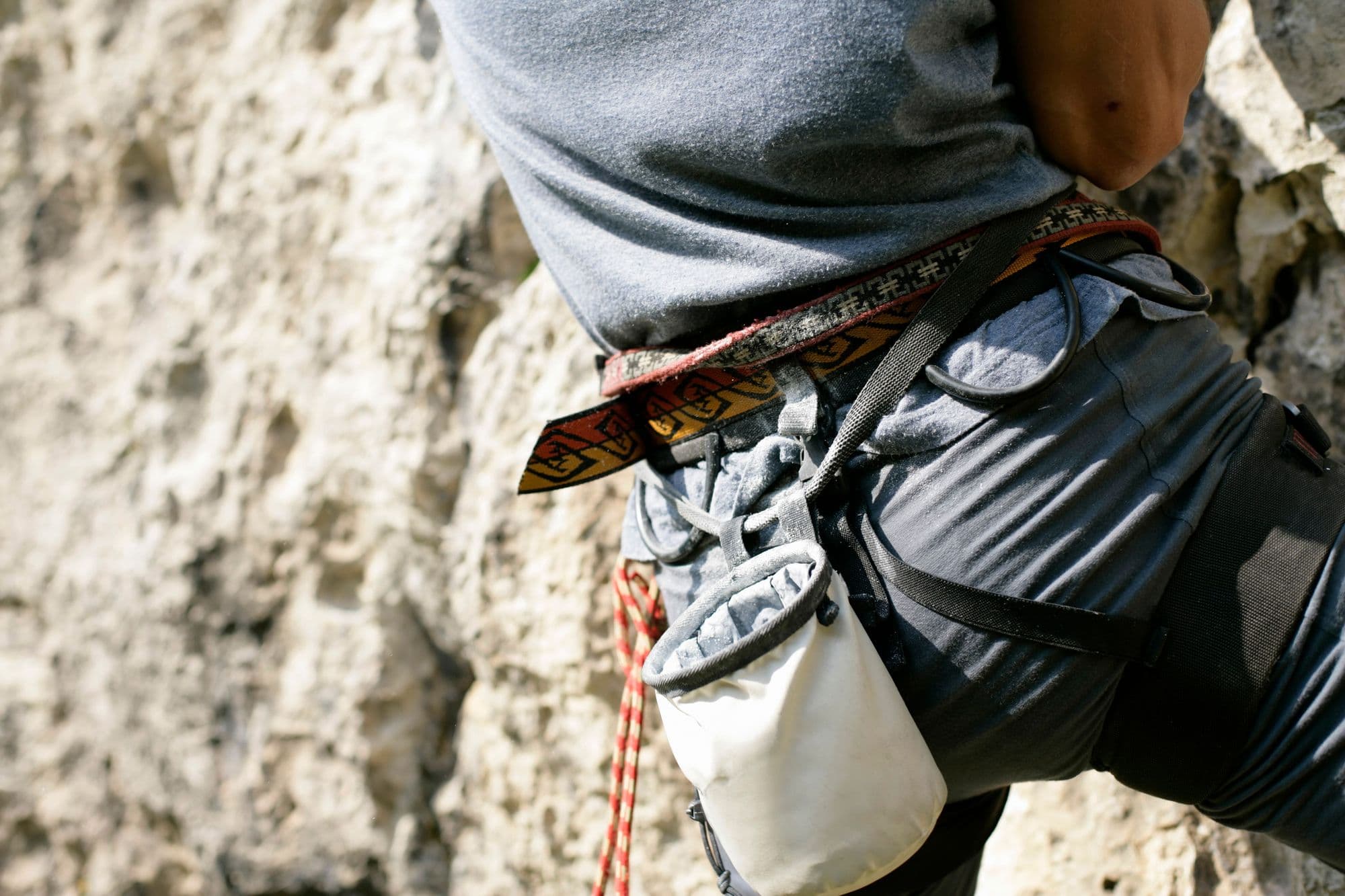 Close-up of a climber's harness and chalk bag on rock