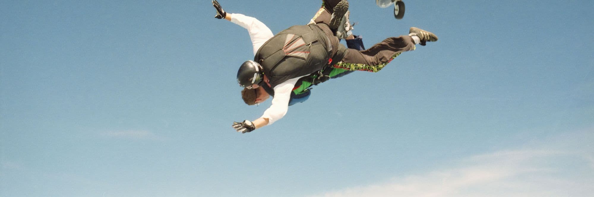 Student skydiver leaving the aircraft in freefall with instructors