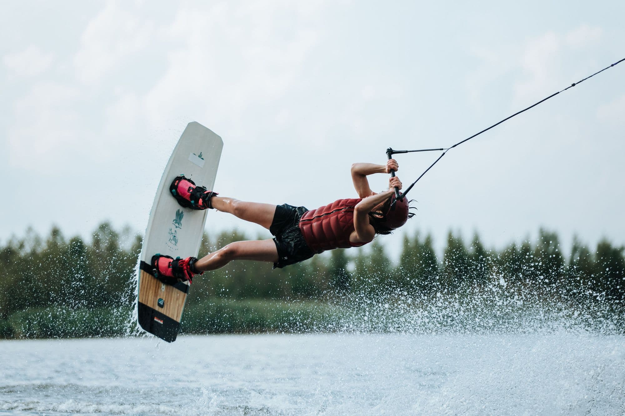 Wakeboarder inverted mid-trick at a cable park